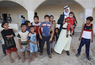 Israeli Bedouin Shahadeh Abu Arar stands with some of his 67 children outside his home in the town of Emek Hefer, Israel , in this photo taken Sunday, Oct. 7, 2007. With eight wives and 67 children,Abu Arrar has given new meaning to the term family man. Arrar, 58, is a member of Israel's impoverished Bedouin Arab community. But even in a traditional society where men commonly have several wives and many children, Abu Arrar is exceptional. (AP Photo/Shaul Golan) 